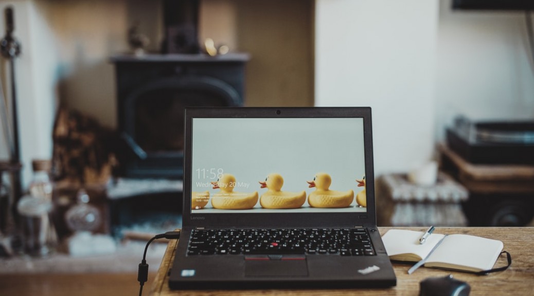 A picture of an open laptop in someone's house. On the screen are a row of plastic ducks. How to manage remote staff.